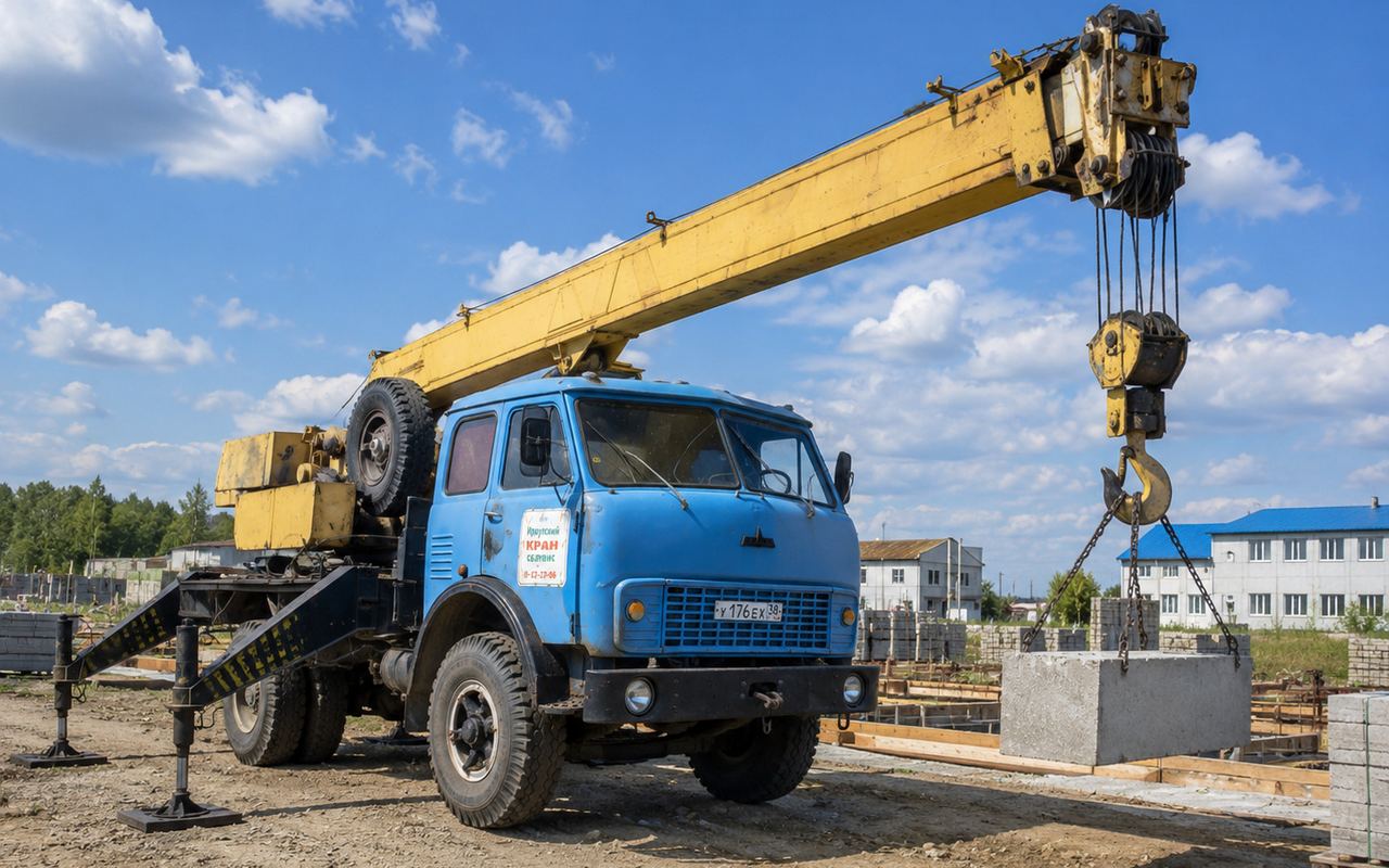 Автокран МАЗ 16 т поднимает бетонный блок